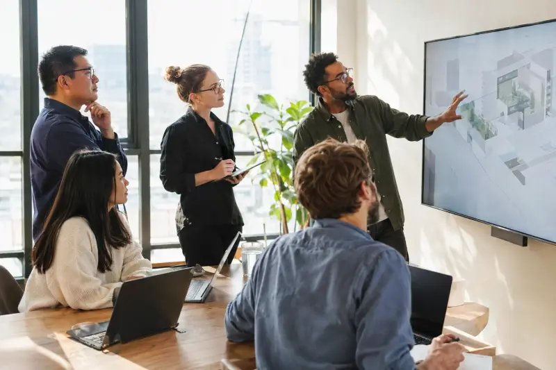 Team gathered around a screen in a bright office