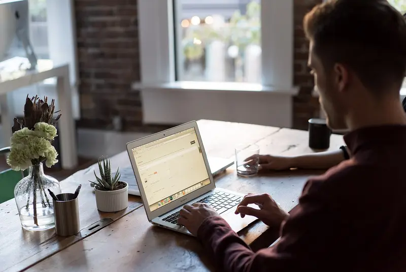Person working on a laptop at a desk in an office
